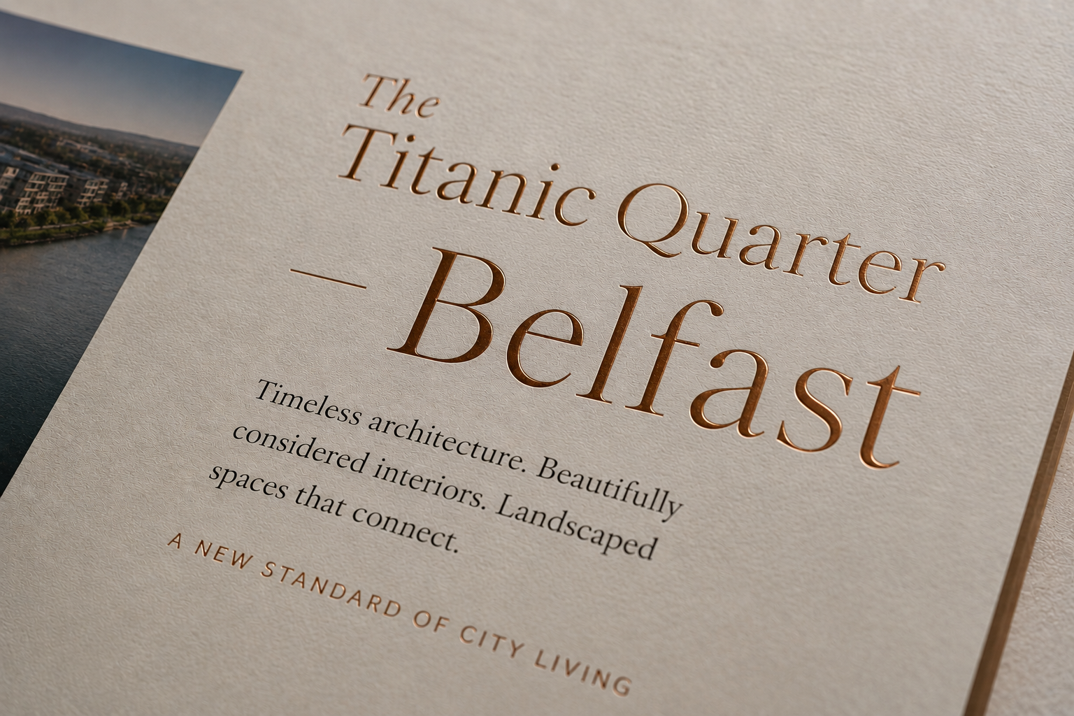 Close-up of a property brochure cover with gold foil serif typography reading The Titanic Quarter, Belfast, designed by Pixelo Design